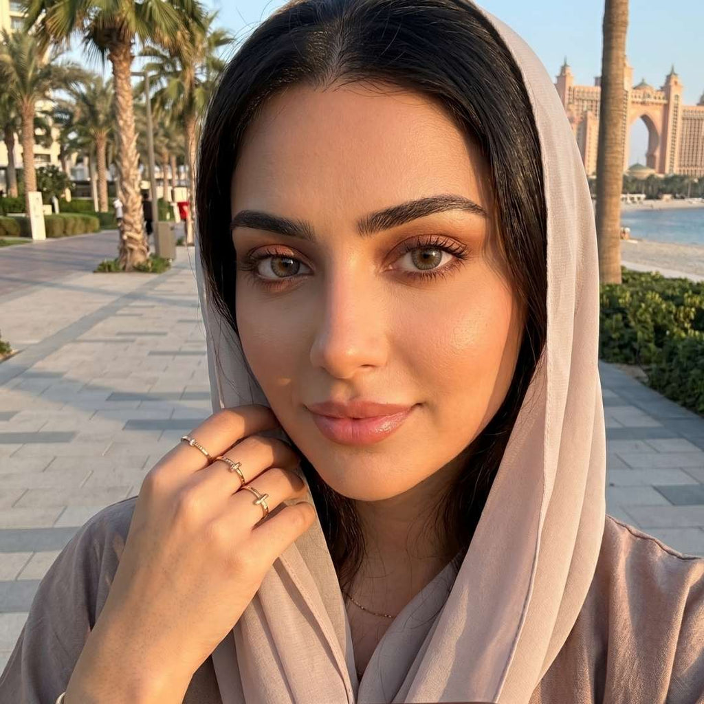 Woman wearing a headscarf with a scenic background of palm trees and buildings.