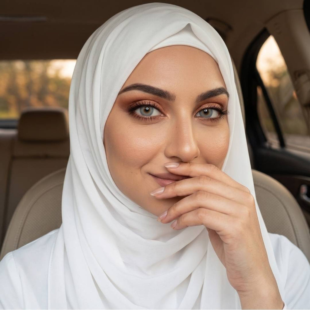 Beautiful young woman in a white hijab, wearing coco gray contact lenses, sitting inside a car.