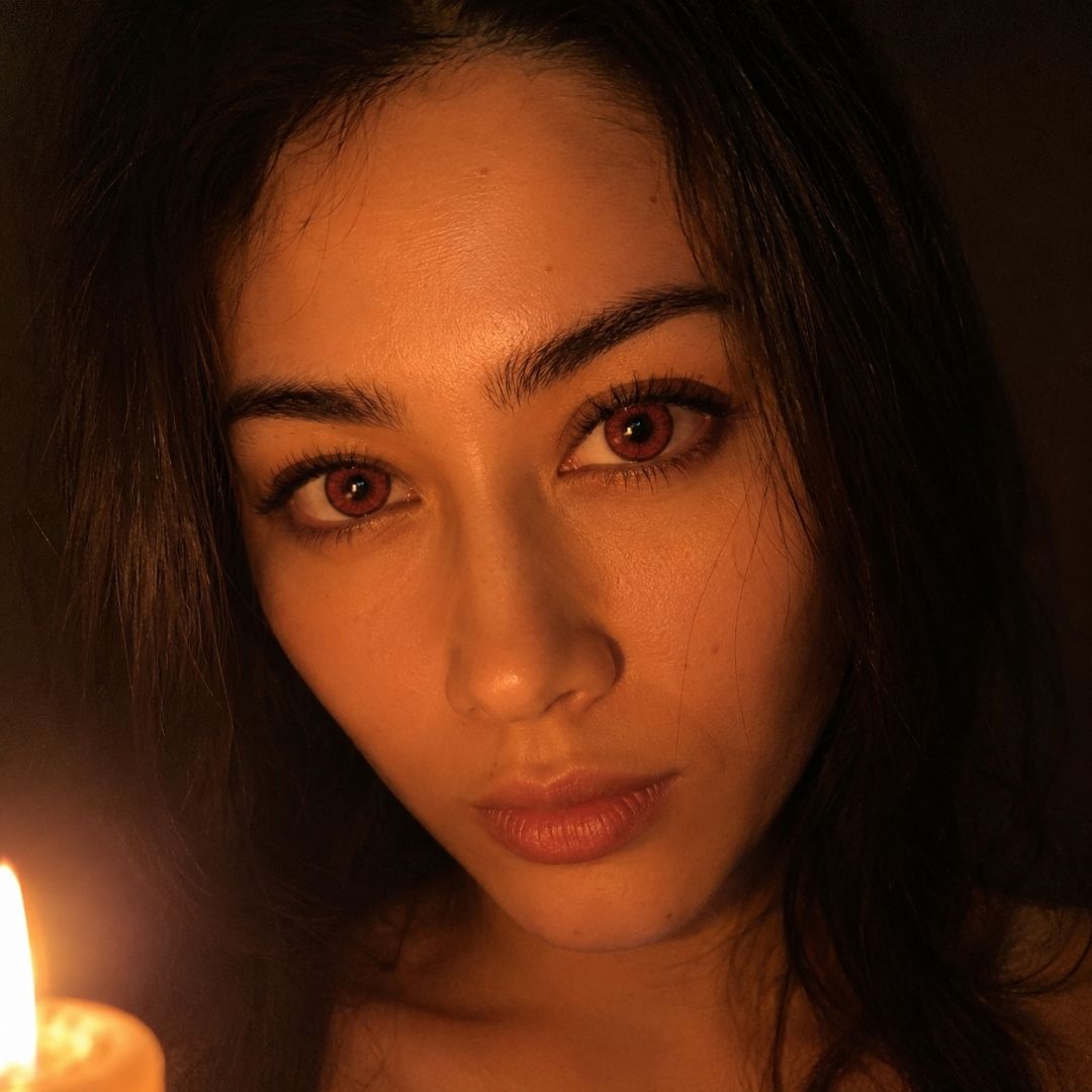 Red eye woman with a candle in a dimly lit setting