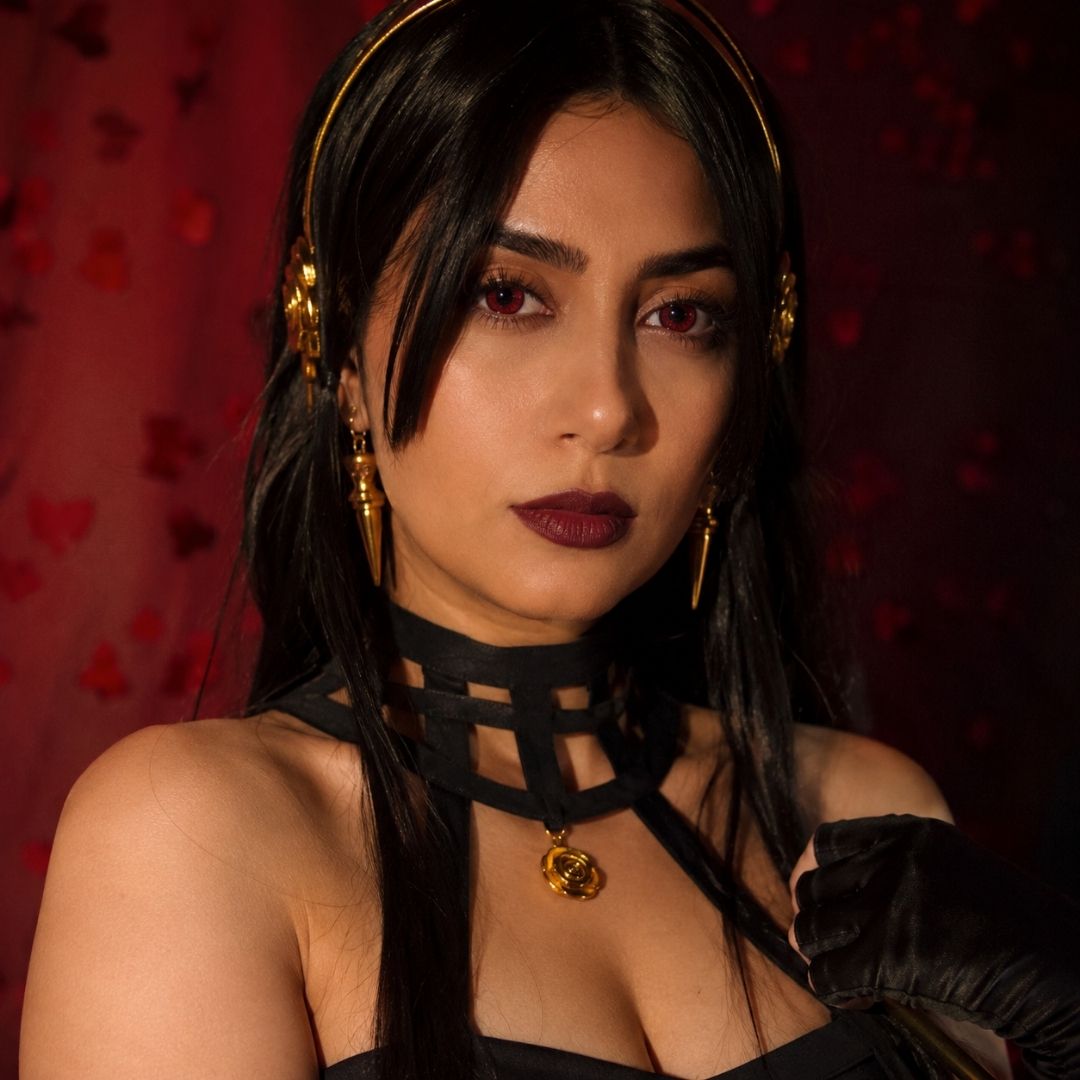 Woman wearing a black choker with gold accents against a red patterned background
