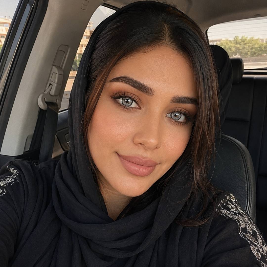Woman wearing a black hijab and beautiful gray lenses sitting inside a car.