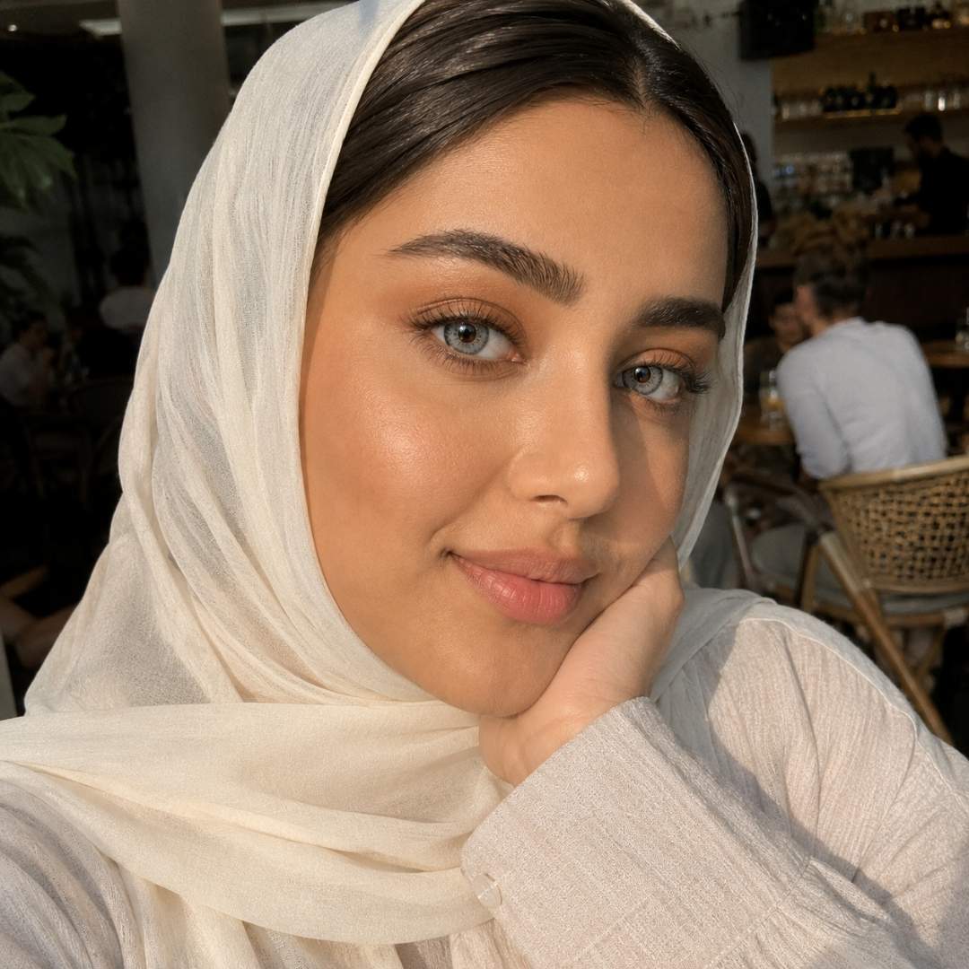 Woman wearing a light-colored hijab in an indoor setting
