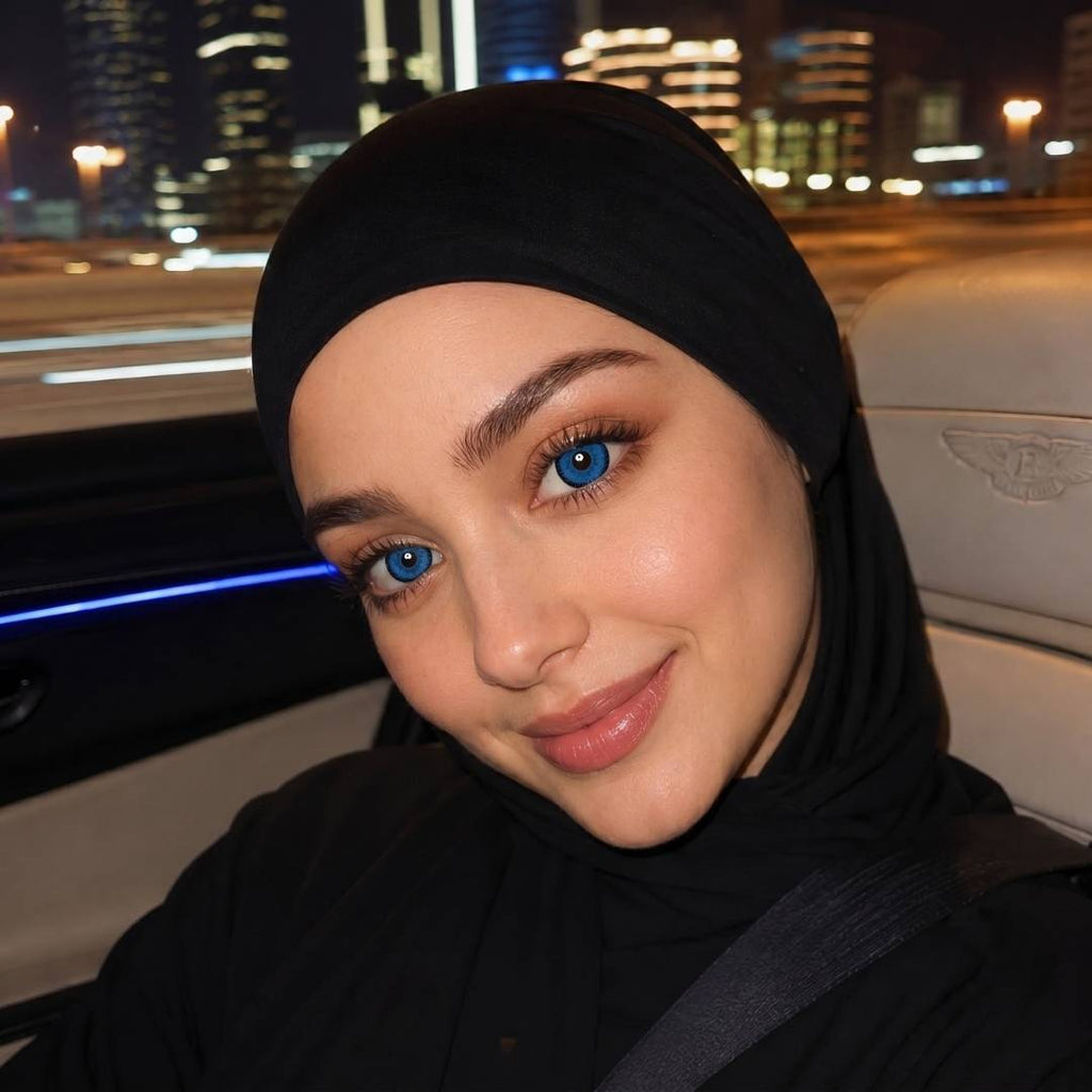 Woman wearing a black hijab with a cityscape in the background