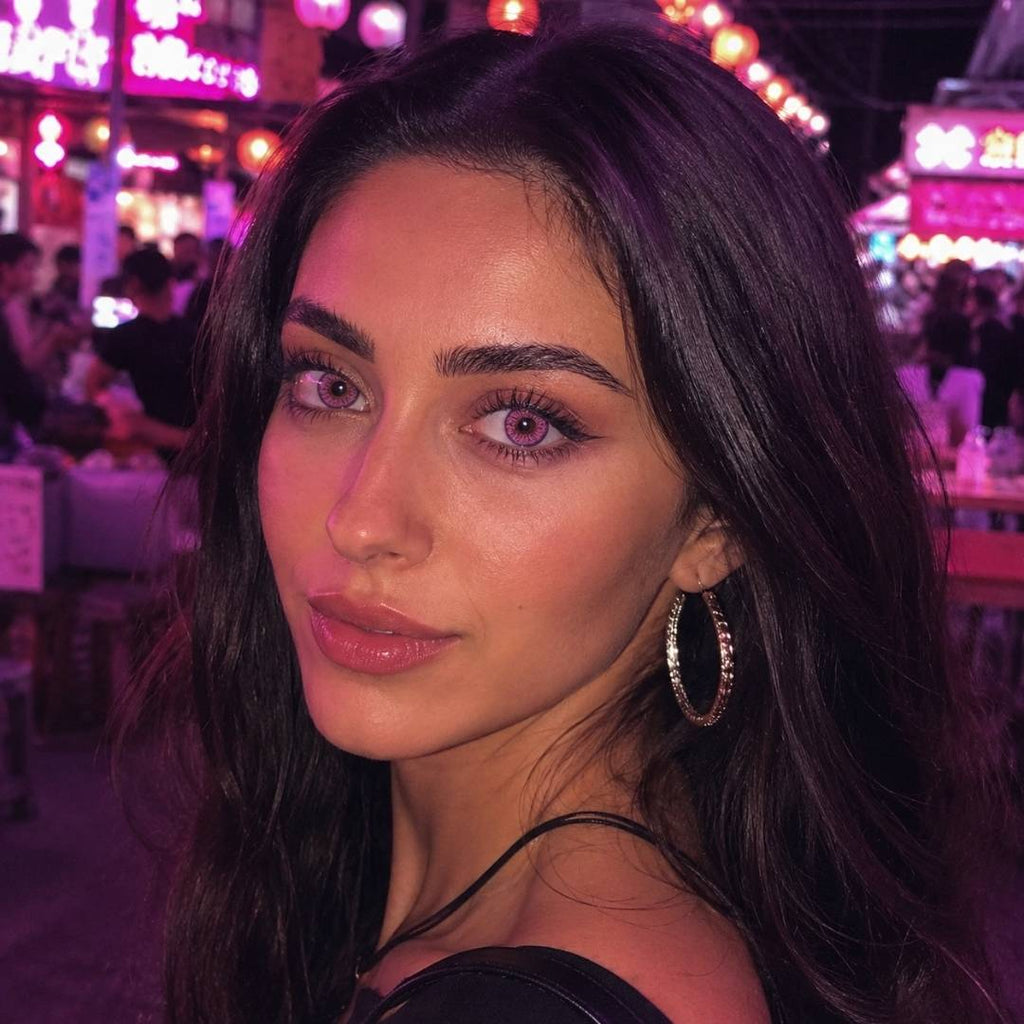Woman with dark hair and hoop earrings in a vibrant, colorful setting