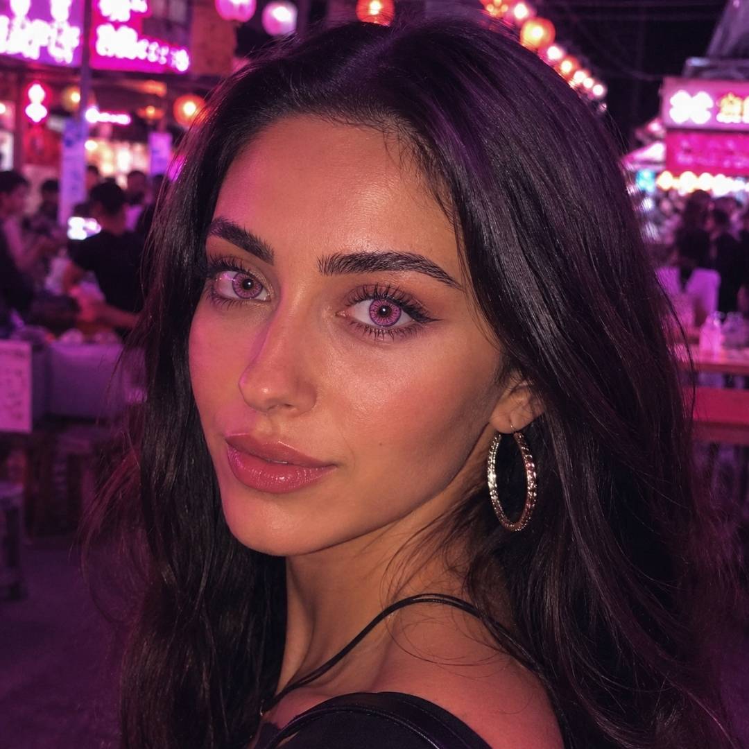 Woman with dark hair and hoop earrings in a vibrant, colorful setting