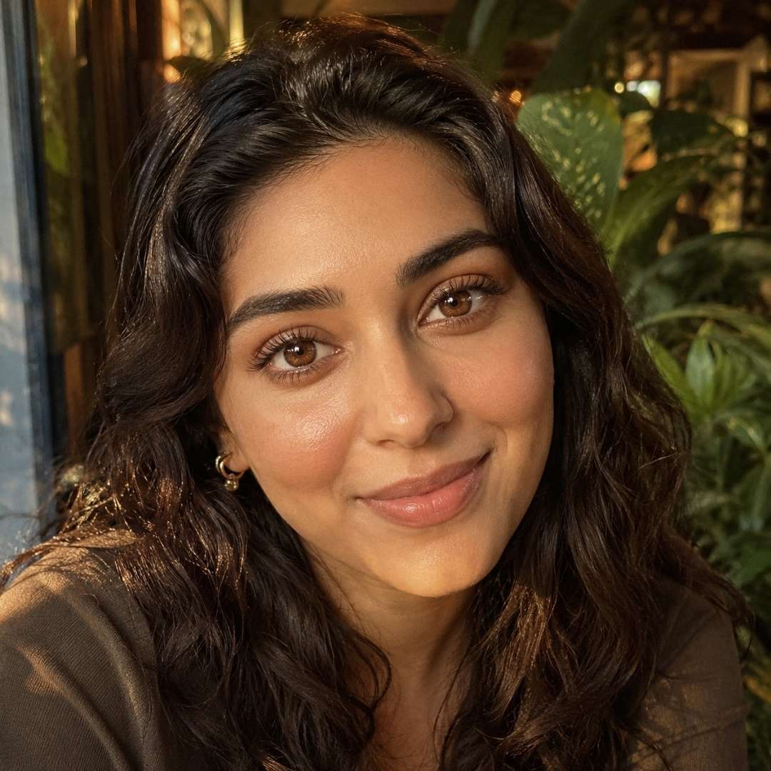 Woman with dark hair and brown eyes smiling outdoors