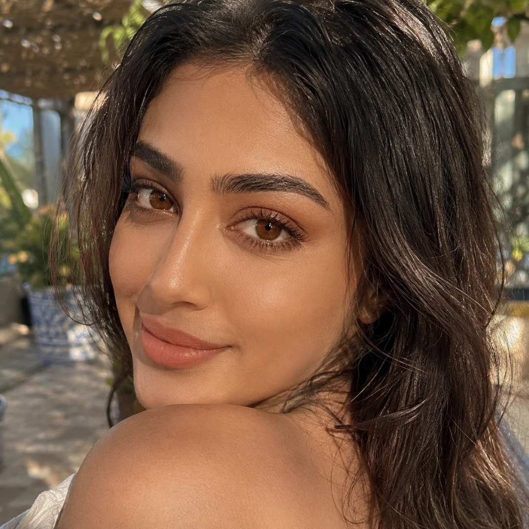 Woman with wavy hair smiling outdoors